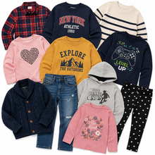 Load image into Gallery viewer, A flat lay of children's clothing for fall/winter, including a navy crewneck sweatshirt with 'NEW YORK ATHLET 1992' text, a pink sweatshirt with a heart graphic, a mustard yellow sweatshirt with 'EXPLORE THE OUTDOORS' text, a gray hoodie with 'HOMEN SKATE CREW' text, a pink 'Be Kind' graphic sweatshirt, a navy cable-knit cardigan, a red plaid button-down shirt, a cream and navy striped sweater, a navy sweatshirt with a video game controller graphic, blue jeans, and black leggings with white hearts.
