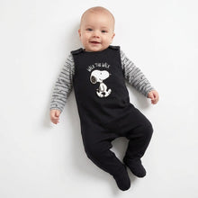 Load image into Gallery viewer, A baby lying on a white background wearing a black footed jumpsuit with a white Snoopy graphic and the words 'WALK THE WALK' over a gray and white striped long-sleeve shirt.
